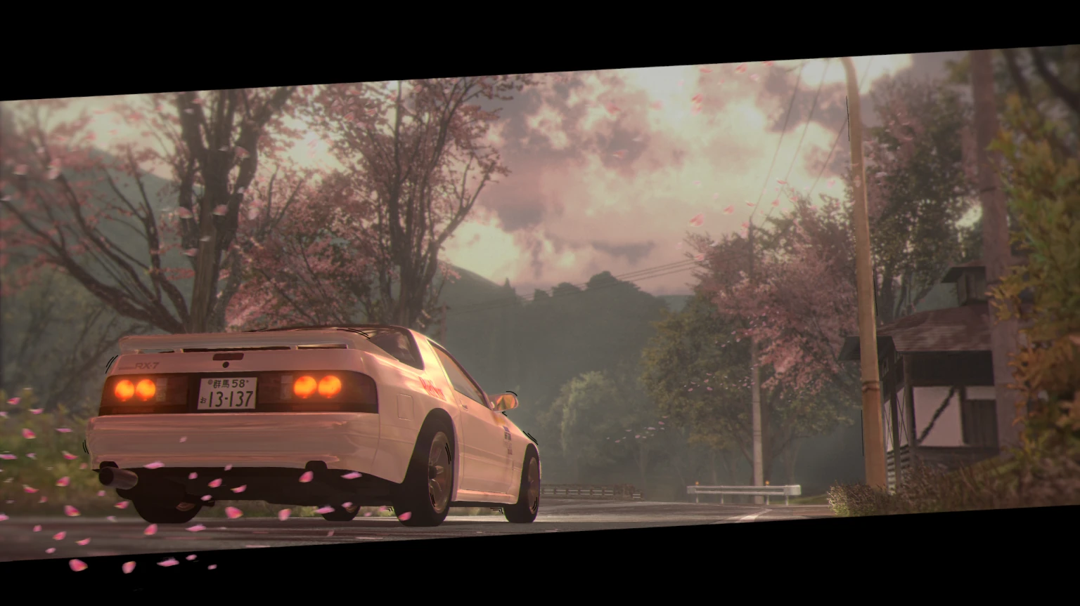 A white RX-7 FC3S under cherry blossom on a pass